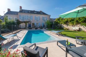 una piscina di fronte a una casa di 5 Grande Rue a Le Lude