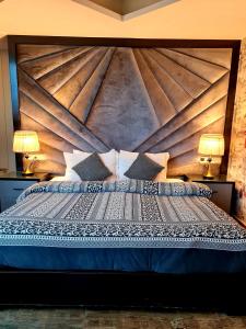 a bedroom with a large bed with a wooden headboard at Royal Residencia Centaurus in Islamabad