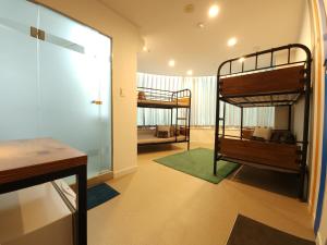 ソウルにあるOYO Hostel Myeongdong 3の二段ベッド2台とテーブルが備わる客室です。