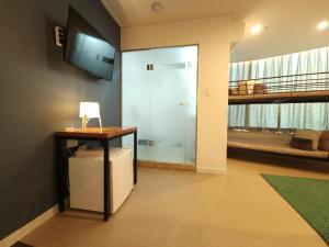 Habitación con escritorio y TV en la pared. en OYO Hostel Myeongdong 3, en Seúl