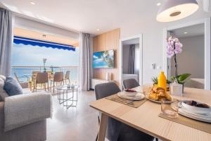 eine Küche und ein Wohnzimmer mit einem Tisch und einem Esszimmer in der Unterkunft Mara Boutique Apartments in Benidorm