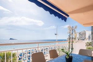 Vom Balkon mit einem Tisch und Stühlen genießen Sie Strandblick. in der Unterkunft Mara Boutique Apartments in Benidorm