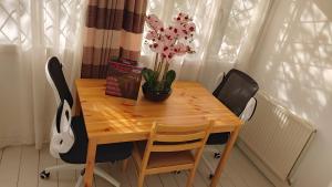 einen Holztisch mit einer Blumenvase darauf in der Unterkunft London Marylebone Grendon rooms in London