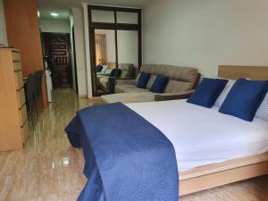 a bedroom with a large bed and a living room at Marina Beach in Puerto de la Cruz