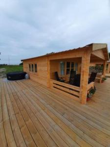 een groot houten terras met een huis erop bij jacuzzi cows dairyfarm relaxing sleeping in Hitzum