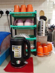 a coffee pot sitting on a red rug in a kitchen at MBI Homestay, Wakaf Che Yeh Kota Bharu in Wakaf Che Yeh