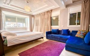a bedroom with a bed and a blue couch at Cruz Hyper centre 4 or 5 Px in Agadir