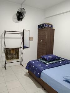 a bedroom with a bed and a mirror and a dresser at MBI Homestay, Wakaf Che Yeh Kota Bharu in Wakaf Che Yeh