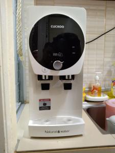 a white coffee maker sitting on a kitchen counter at MBI Homestay, Wakaf Che Yeh Kota Bharu in Wakaf Che Yeh