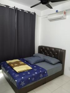 Cama en habitación con ventilador de techo en MBI Homestay, Wakaf Che Yeh Kota Bharu, en Wakaf Che Yeh