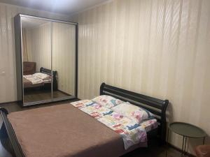Schlafzimmer mit einem Bett und einem Spiegel in der Unterkunft Apartment on Akhmatovoyi 32/18 in Kiew