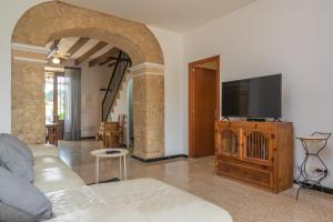 a living room with a couch and a flat screen tv at Son Indiot in Algaida