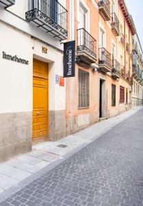 een straat met een gele deur op een gebouw bij limehome Madrid San Lorenzo in Madrid
