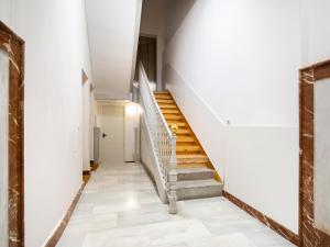 una escalera en un edificio antiguo con paredes y suelos blancos en limehome Madrid San Lorenzo, en Madrid