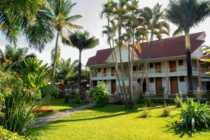 uma casa com palmeiras em frente em Hotel Safari Gate em Bujumbura
