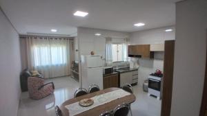 eine Küche mit einem Tisch und Stühlen sowie einem Kühlschrank in der Unterkunft Casa aconchegante com piscina e bem localizada in Foz do Iguaçu