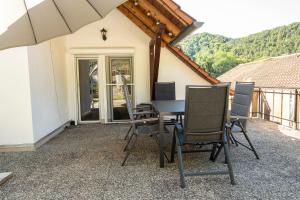 patio con mesa y sillas en el balcón en Ferienhaus Zum Waldrand, en Erfweiler