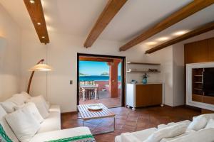 a living room with white furniture and a view of the ocean at Le case del golfo in Golfo Aranci