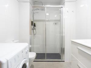 a white bathroom with a shower and a toilet at limehome Madrid San Lorenzo in Madrid