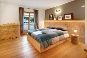 a bedroom with a wooden bed and a wooden dresser at Casa Alù Larice in Bormio