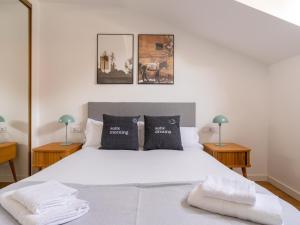 een slaapkamer met een groot wit bed met 2 lampen bij limehome Madrid San Lorenzo in Madrid