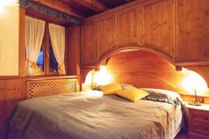 1 dormitorio con 1 cama grande de madera y 2 almohadas amarillas en Mansarda su due livelli nel cuore delle Dolomiti en San Vito di Cadore