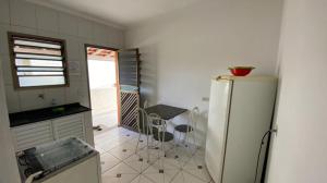a kitchen with a refrigerator and a table in it at Apartamentos PraiaMar in Ilha Comprida