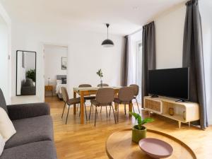 a living room with a couch and a table with a television at limehome Madrid San Lorenzo in Madrid