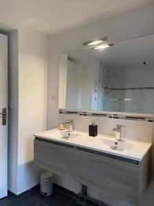 uma casa de banho com 2 lavatórios e um espelho grande em Maison 6 personnes hippodrome de Compiègne em Compiègne