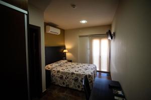 a small bedroom with a bed and a window at Hostal Restaurante La Bartola in Santa Cruz