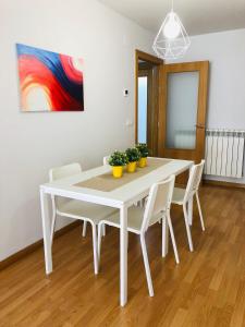 カステホンにあるApartamentos Ribera Navarra - Bardenasの白いダイニングテーブル(白い椅子付)