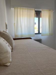 1 dormitorio con 1 cama con 2 almohadas y ventana en Dpto GUALEGUAYCHU centro en Gualeguaychú