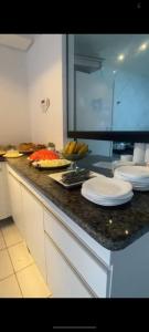 um balcão de cozinha com pratos e frutas em Pousada Mar de Maceió em Maceió