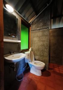 a bathroom with a toilet and a sink with a green window at 467 Chiang Dao in Chiang Dao