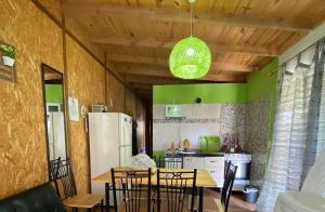 a kitchen with a table and chairs and a refrigerator at Cabaña OHANA ALVORADA -BARRA CHUY BRASIL in Chuy