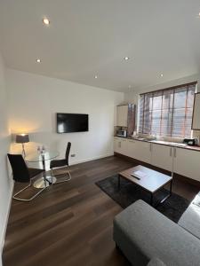 a living room with a table and a couch at Howburn Residence Serviced Apartments - 1,2& 3 Bedroom Apartments in Aberdeen