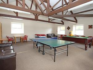 um quarto com uma mesa de pingue-pongue e cadeiras em 32 Manorcombe em Callington