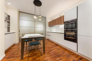 a kitchen with white cabinets and a table and chairs at Casa da Suite Costanza in Milan