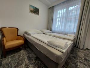 1 dormitorio con 1 cama, 1 silla y 1 ventana en Kamienica1924, en Szczecinek