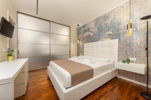 a bedroom with a white bed and a bathroom at Casa da Suite Costanza in Milan