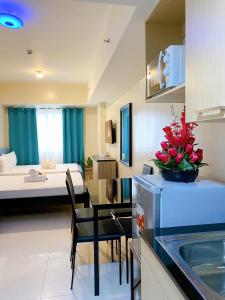 a hotel room with a kitchen and a bedroom at Luxury Suites at Brenthill Baguio City in Baguio
