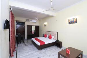 ein Schlafzimmer mit einem Bett und einem Tisch in einem Zimmer in der Unterkunft OYO Hotel Ayaan in Bareilly