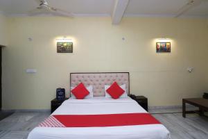 una camera da letto con un grande letto con cuscini rossi di OYO Hotel Ayaan a Bareilly