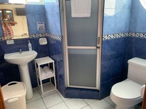a bathroom with a shower and a toilet and a sink at Hotel Kemarios in Tonsupa