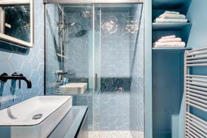 a blue bathroom with a shower and a sink at Luxueuze suite met frontaal zeezicht in Knokke-Heist