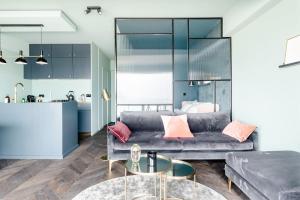 a living room with a couch and a table at Luxueuze suite met frontaal zeezicht in Knokke-Heist