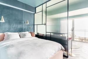 een slaapkamer met een groot bed en een blauwe muur bij Luxueuze suite met frontaal zeezicht in Knokke-Heist