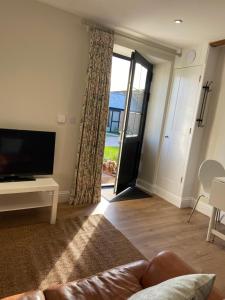 a living room with a couch and a sliding glass door at Potcote farm stables accommodation spots stable in Towcester