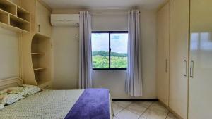 a bedroom with a bed and a window at Mirante das Aguas de Piratuba in Piratuba