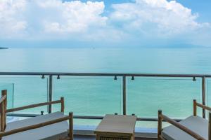 Un balcón con sillas y vistas al océano. en Riviera Beach Hotel en Bophut 